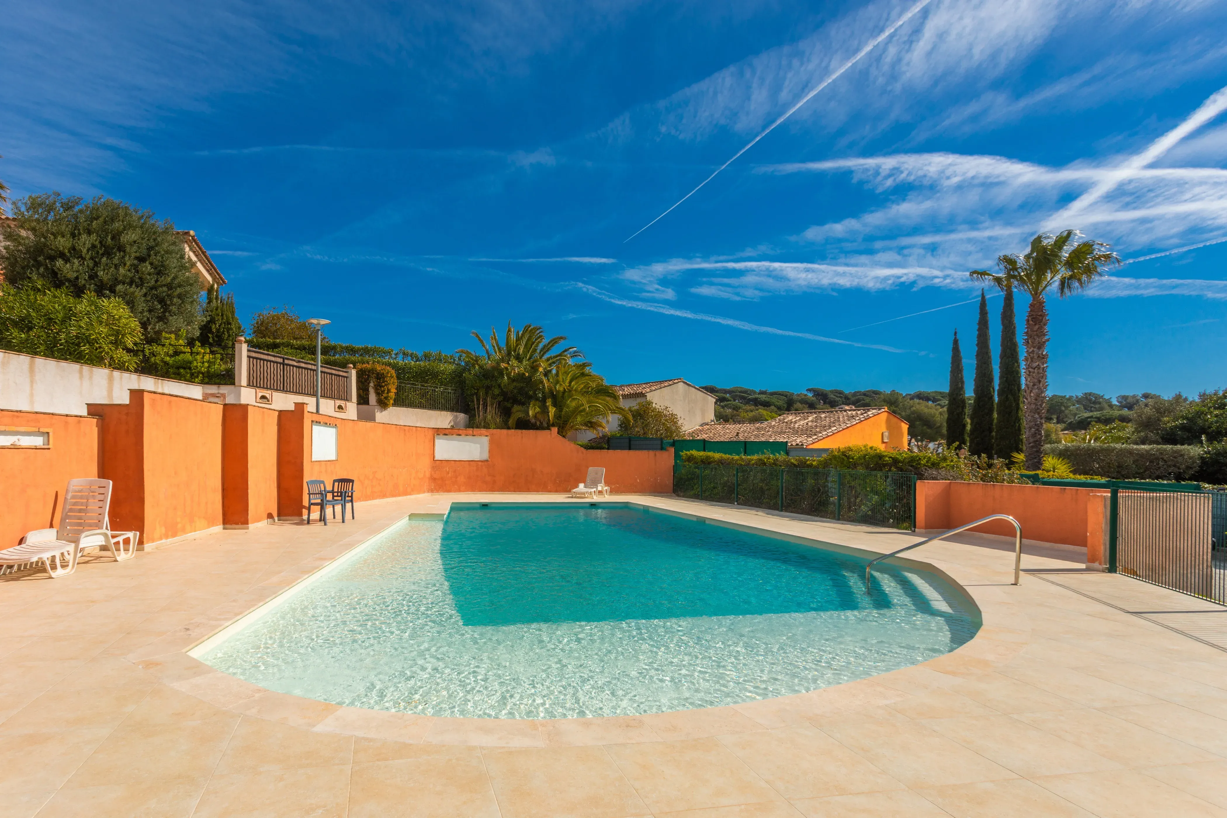 Outdoor pool surrounded by greenery